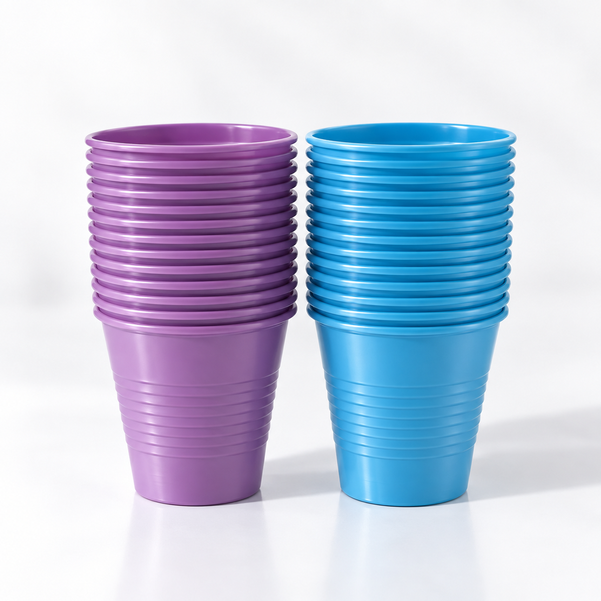 Two stacks of Posi Shield 5 oz. dental plastic cups with a ribbed exterior, one in lavander purple and the other in bright blue, set against a clean white background.