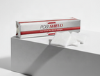 A box of Posi-Shield non-woven sponges sits on a white pedestal with several white square sponges placed in front. The packaging is white with red stripes and black text.